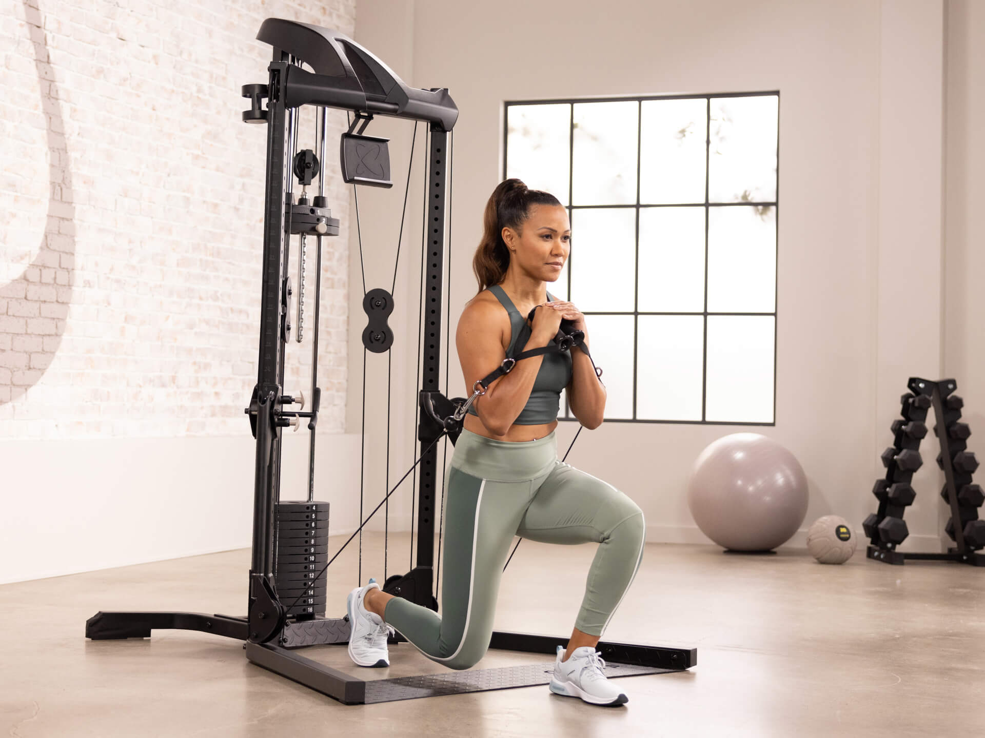 Woman using cable machine to perform exercises